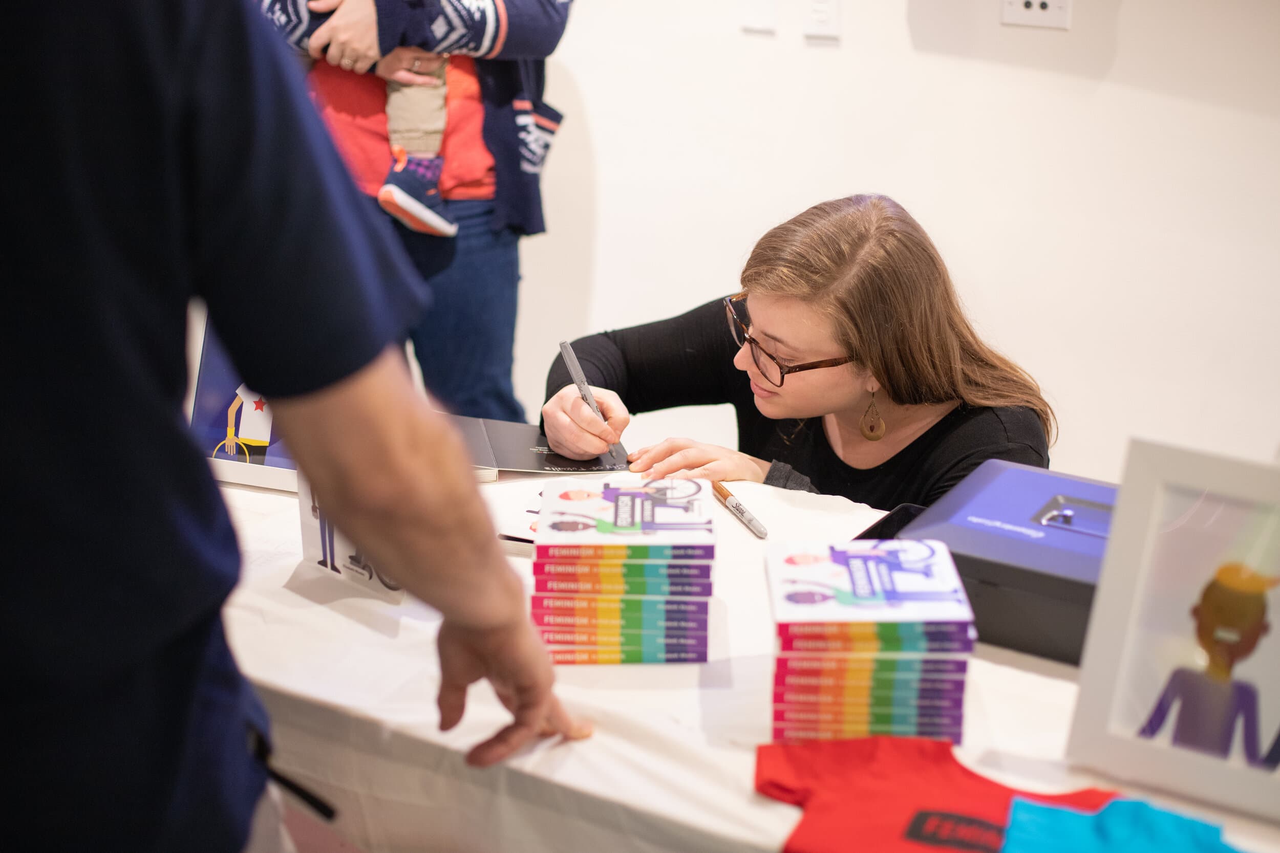 Elizabeth signing copies of Feminism is for Boys at a book event