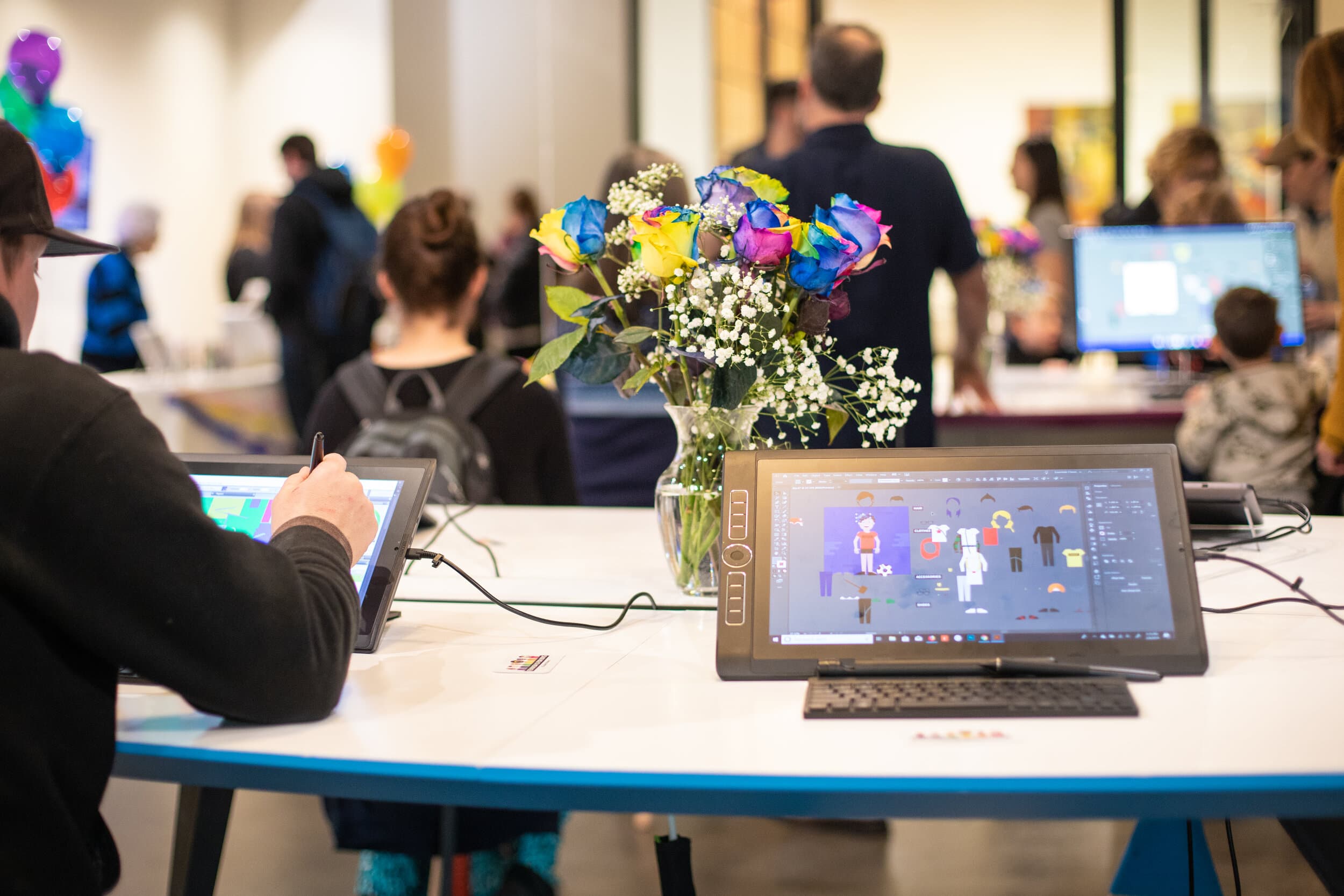 Kids and families at a Feminism is for Boys book event with drawing tablets